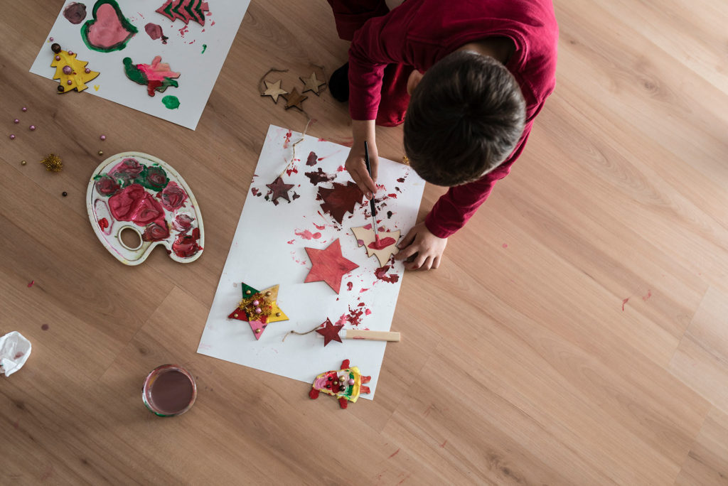 Niño pintando adornos navidad