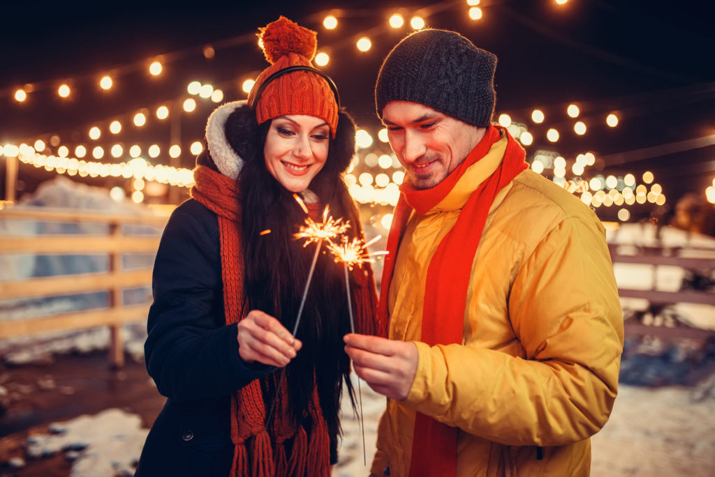 Pareja con bengalas y luces al fondo desenfocadas